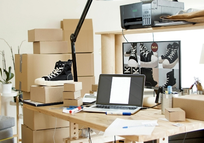 Bureau remplis de boites et de commandes avec un ordinateur sur le bureau - souliers - boutique en ligne transactionnelle