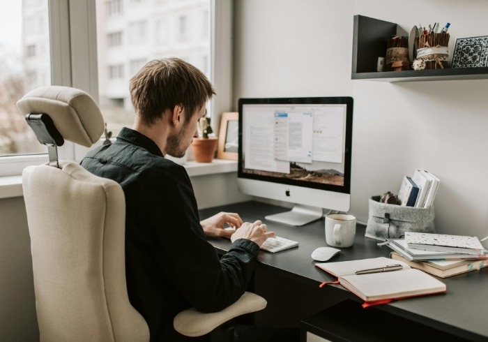homme assis à un bureau avec un ordinateur qui fait un audit SEO - SEO complet