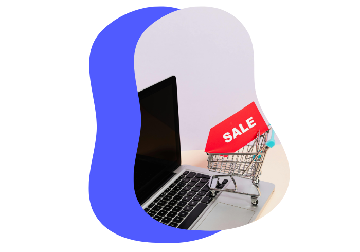 Ordinateur avec un panier dessus ainsi qu'un étiquette qui inscrit une vente - Site transactionnel shopify